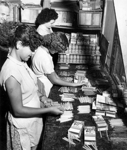 Young women packing Hanukkah candles in a workshop, Eretz Israel, 1940s. Photo: Leni Sonnenfeld Beth Hatefutsoth Photo Archive, Sonnenfeld collection)